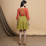 Back View of a Model wearing Green Pleated Cotton Flax Knee Length Criss-Cross Back Dress