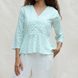 Front Detail of a Model wearing Green Floral Block Printed Cotton Button-Down Peplum Top