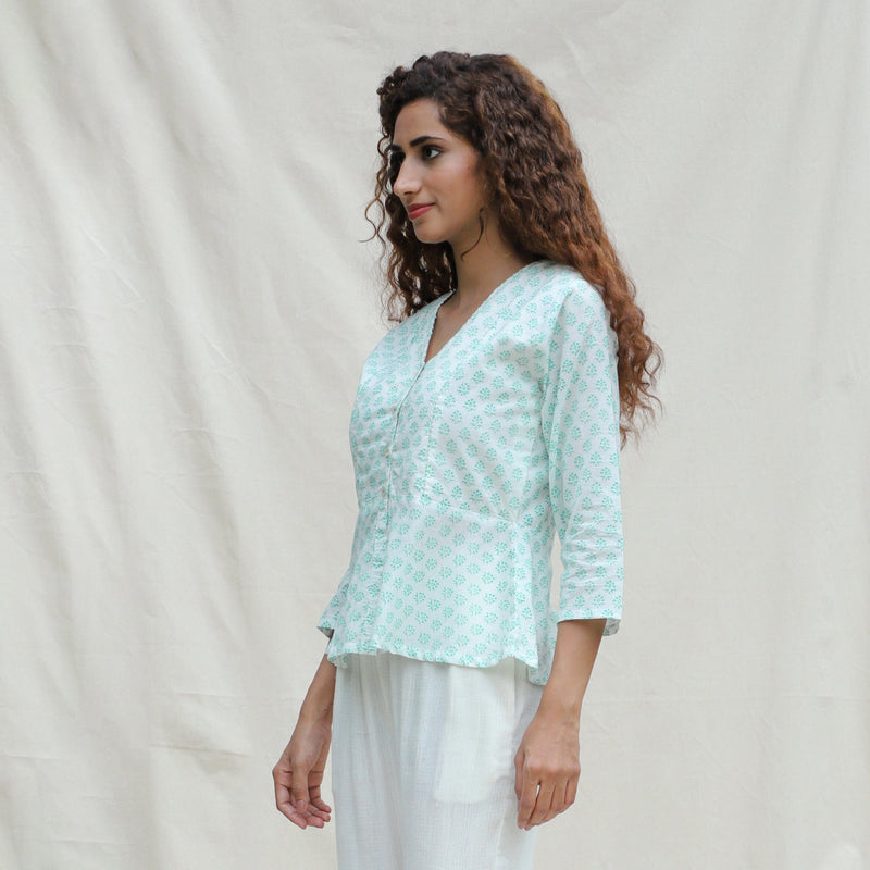 Left View of a Model wearing Green Floral Block Printed Cotton Button-Down Peplum Top