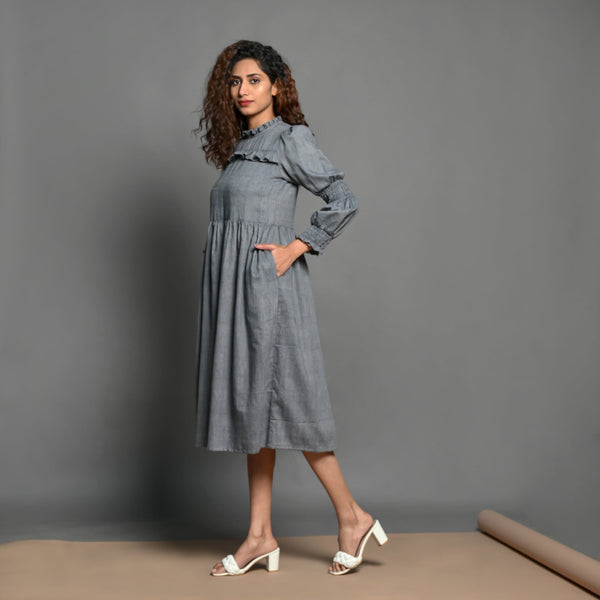 Left View of a Model wearing Slate Grey Handspun Cotton Knee Length Frilled Peasant Dress