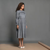 Right View of a Model wearing Slate Grey Handspun Cotton Knee Length Frilled Peasant Dress