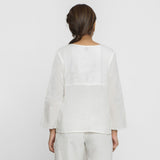 Back View of a Model wearing White Embroidered Organic Cotton Split Neck Top