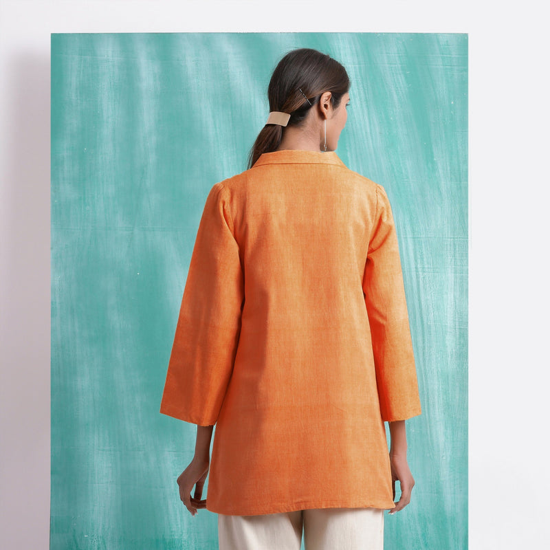 Back View of a Model wearing Handwoven Orange Welt Pocket Coat