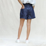 Back View of a Model wearing Indigo Cotton Denim High-Rise Paperbag Elasticated Shorts