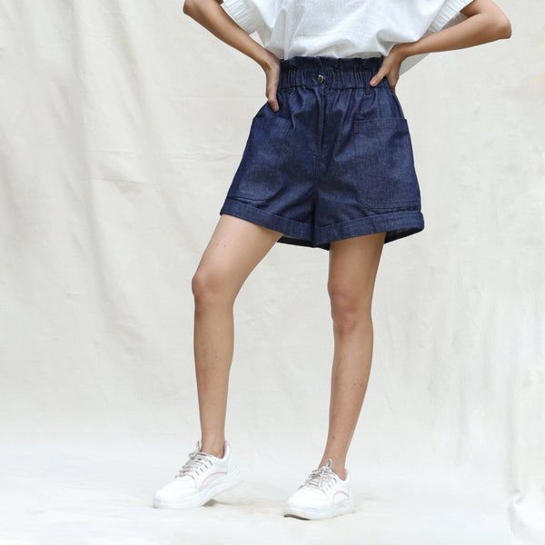 Front View of a Model wearing Indigo Cotton Denim High-Rise Paperbag Elasticated Shorts