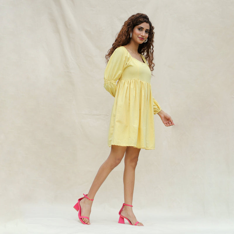 Right View of a Model wearing Light Yellow Handspun Cotton Bohemian Gathered Short Dress