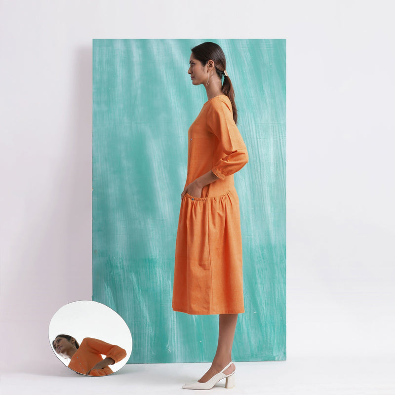 Left View of a Model wearing Melon Orange Comfort Fit Mirror Work Dress