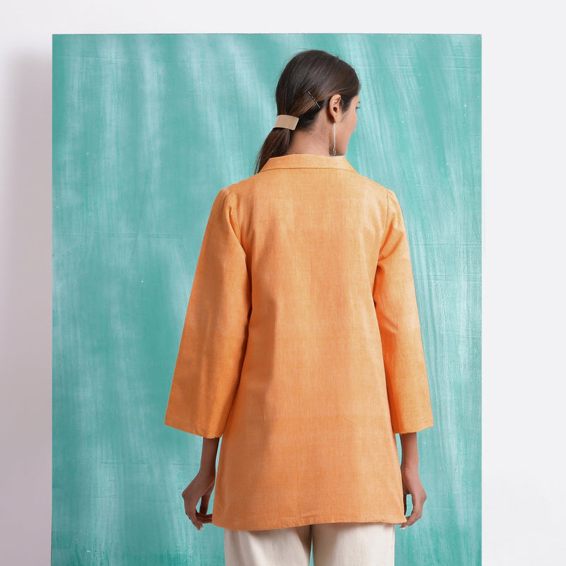 Back View of a Model wearing Melon Orange Welt Pocket Handwoven Coat