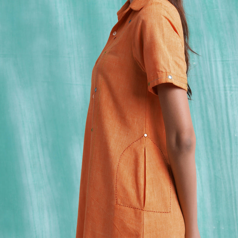 Left Detail of a Model wearing Melon Orange Mirrored Asymmetrical Shirt Dress