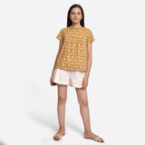 Front View of a Model wearing Mustard Bagru Print Relaxed Fit Top