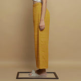 Left View of a Model wearing Mustard Paneled Striped Handwoven Pant