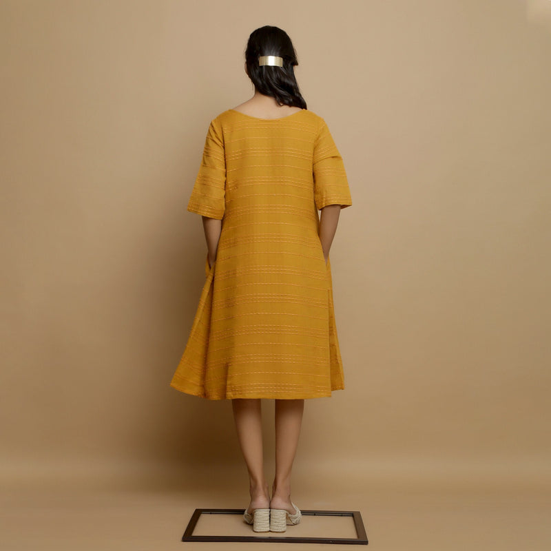 Back View of a Model wearing Mustard Striped Handwoven Godet Dress
