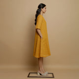 Right View of a Model wearing Mustard Striped Handwoven Godet Dress