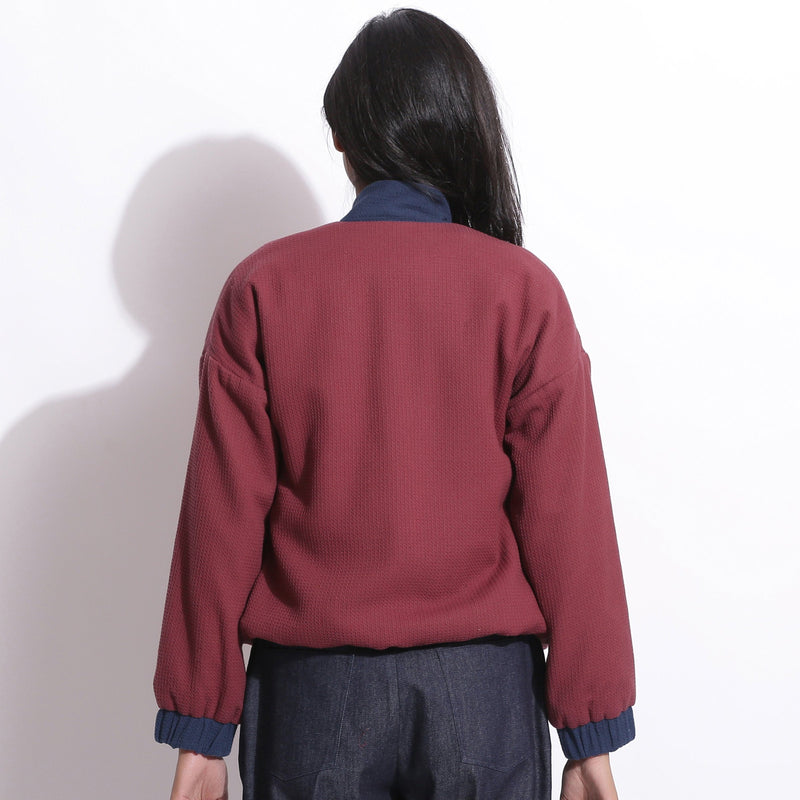Back View of a Model wearing Reversible Blue Red Waffle Bomber Jacket