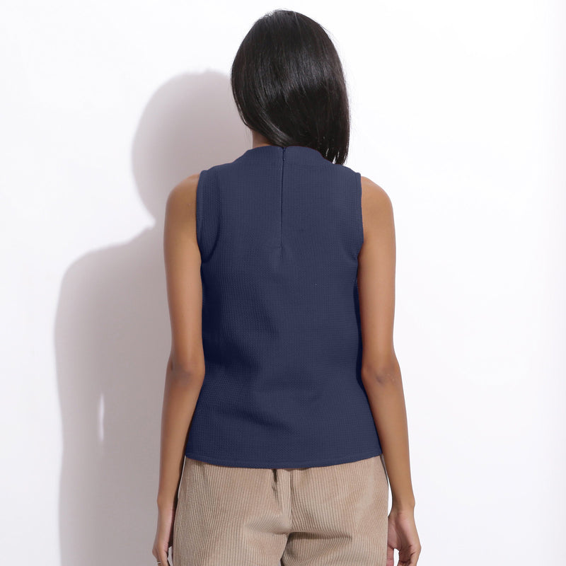 Back View of a Model wearing Navy Blue Cotton Waffle Funnel Neck Top