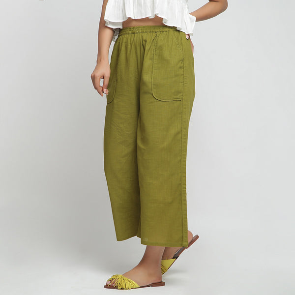 Left View of a Model wearing Olive Green Cotton Mid-Rise Elasticated Wide Legged Pant