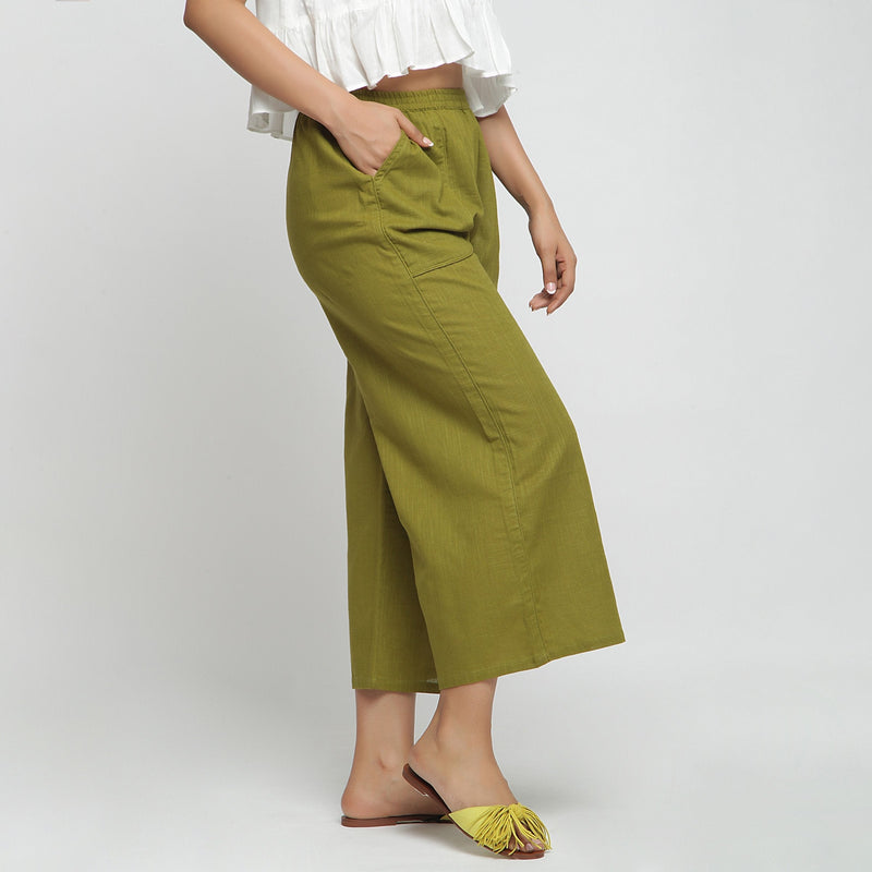 Right View of a Model wearing Olive Green Cotton Mid-Rise Elasticated Wide Legged Pant