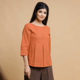 Right View of a Model wearing Orange Yarn Dyed Cotton Pleated High-Low Top