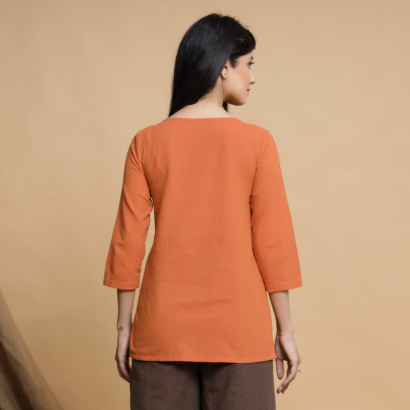 Back View of a Model wearing Orange Yarn Dyed Cotton Pleated High-Low Top