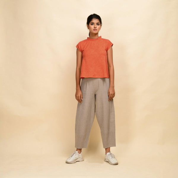 Front View of a Model wearing Orange Flared Top and Beige Pant Set