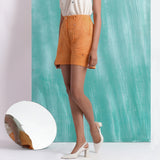 Left View of a Model wearing Orange Handspun Mirror Work Shorts