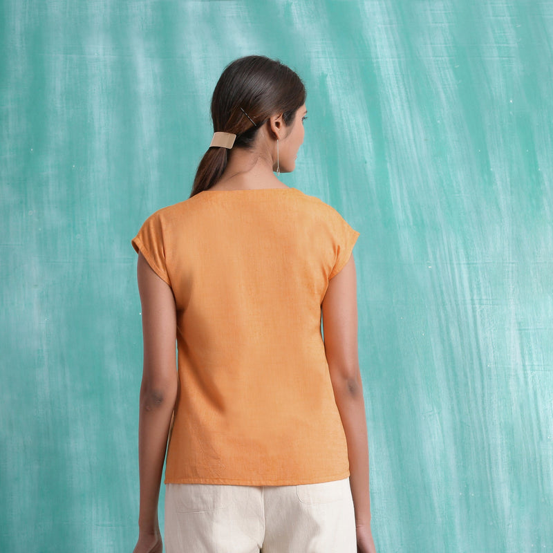 Back View of a Model wearing Orange Hand Mirror Work Drop Shoulder Top