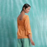 Back View of a Model wearing Orange Handspun Yoked Mirror Top