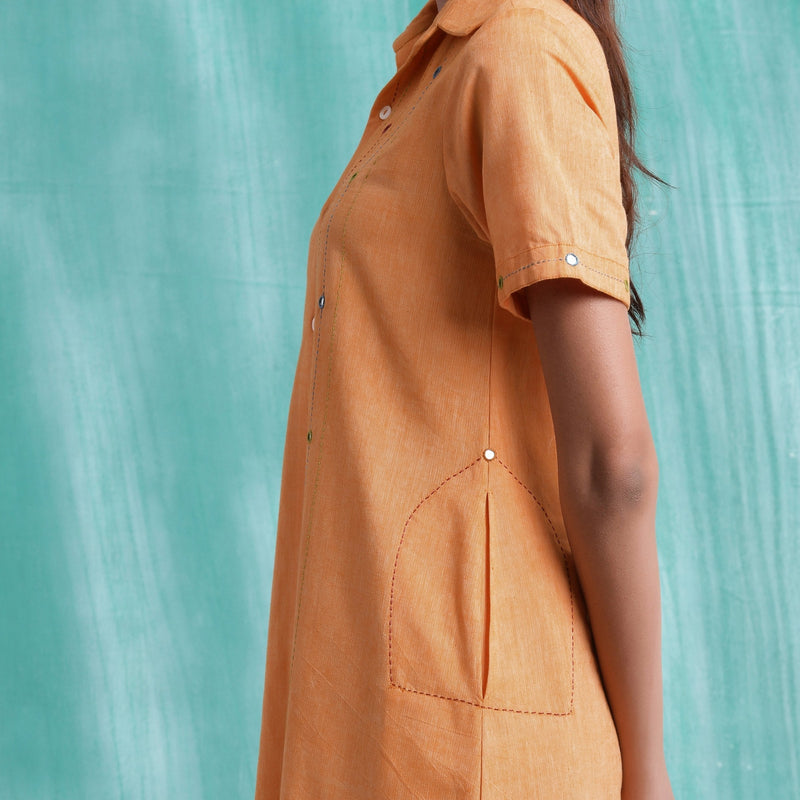 Left Detail of a Model wearing Orange Mirrored Asymmetrical Shirt Dress