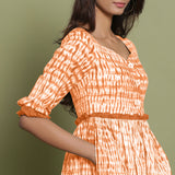 Right Detail of a Model wearing Orange Shibori Asymmetrical Tier Maxi Dress