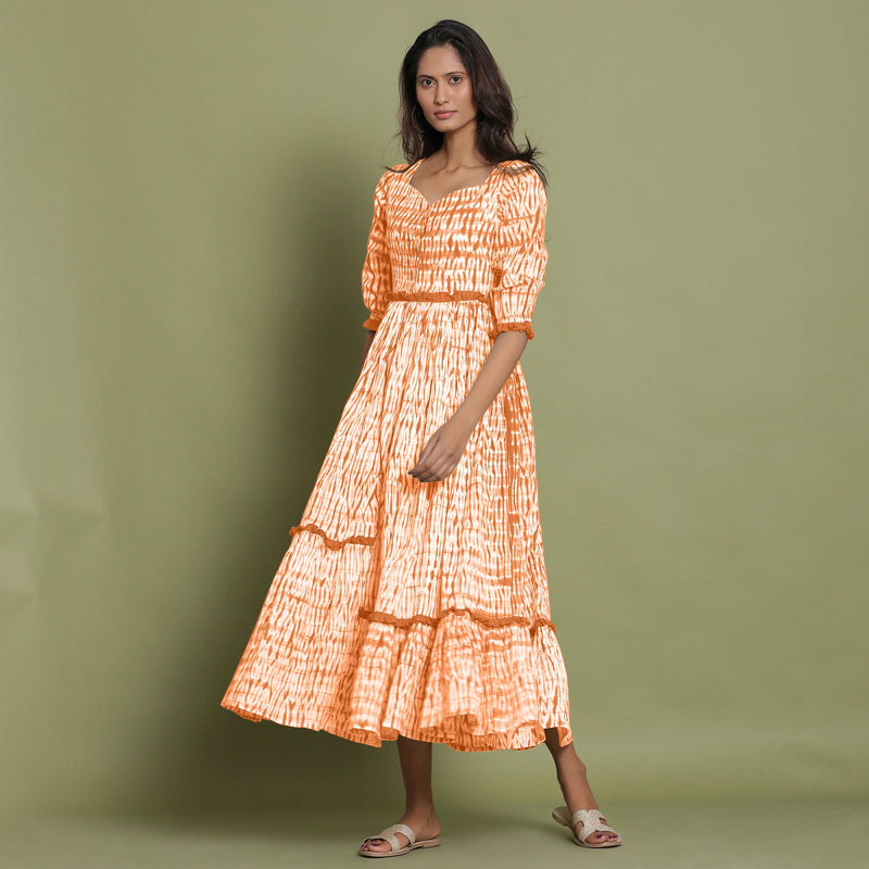 Front View of a Model wearing Orange Shibori Asymmetrical Tier Maxi Dress