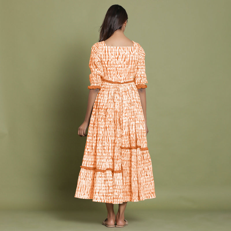 Back View of a Model wearing Orange Shibori Asymmetrical Tier Maxi Dress