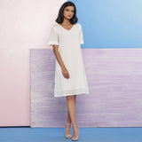 Front View of a Model wearing Organic Cotton White Embroidered V-Neck Dress