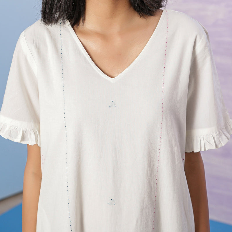 Front Detail of a Model wearing Organic Cotton White Embroidered V-Neck Dress