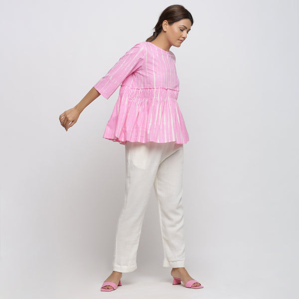 Right View of a Model wearing Pink Cotton Tie-Dye Cotton Gathered Flared Top