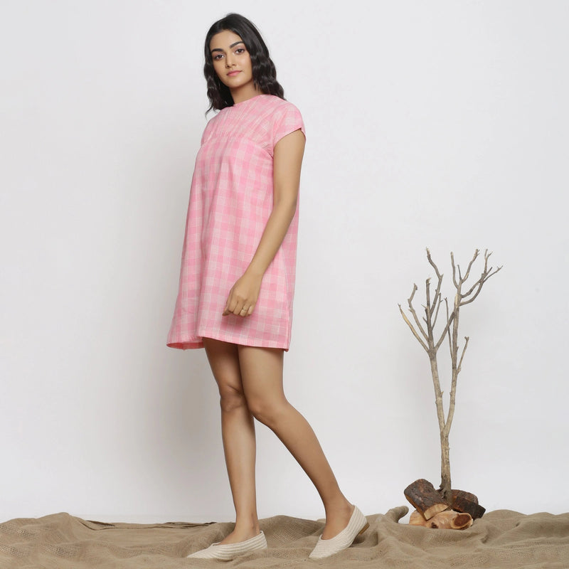 Left View of a Model wearing Powder Pink Checks Handspun Cotton Yoked Mini Dress