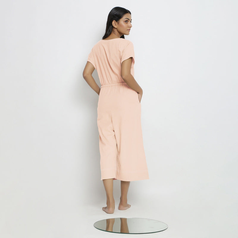 Back View of a Model wearing Powder Pink Vegetable Dyed Button-Down Jumpsuit