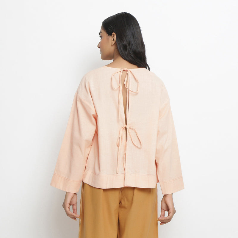 Back View of a Model wearing Powder Pink Vegetable Dyed Cotton Loose Fit Tie Neck Top