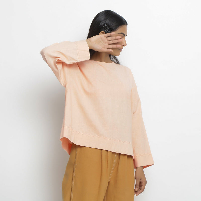 Right View of a Model wearing Powder Pink Vegetable Dyed Cotton Loose Fit Tie Neck Top