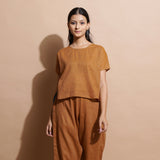 Front View of a Model wearing Rust Cotton Muslin Lined High-Low Top