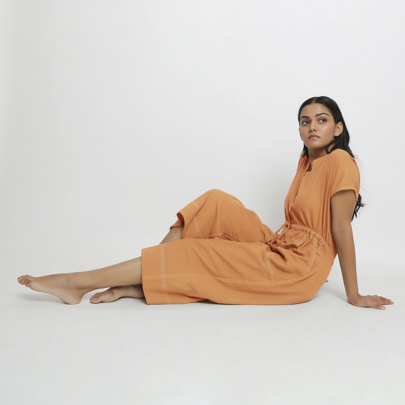 Left View of a Model wearing Rust Vegetable Dyed Button-Down Jumpsuit