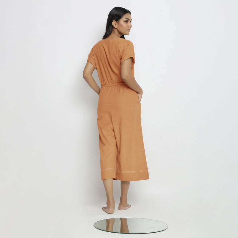 Back View of a Model wearing Rust Vegetable Dyed Button-Down Jumpsuit