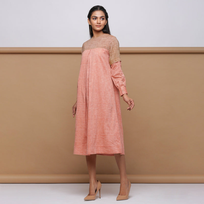 Left View of a Model wearing Salmon Pink Handspun Pleated Dress