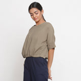 Left View of a Model wearing Solid Beige Cotton Flax Blouson Top