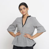 Front View of a Model wearing Solid Grey Yarn Dyed Cotton Peplum Top