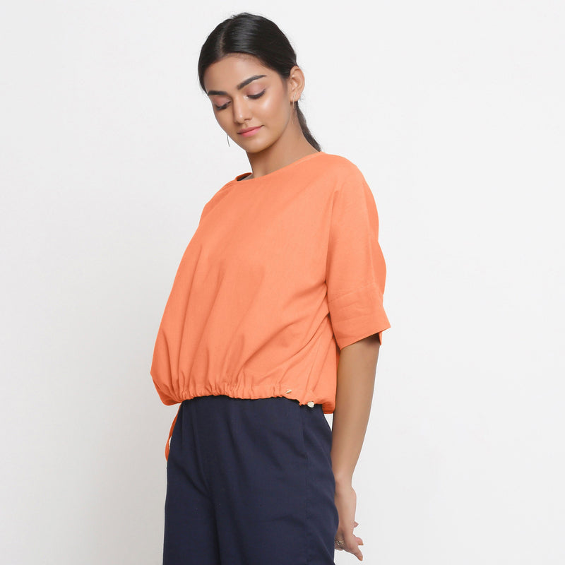 Left View of a Model wearing Solid Peach Cotton Flax Blouson Top