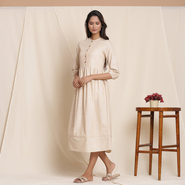 Left View of a Model wearing Dusk Beige Warm Cotton Striped Gathered Midi Dress