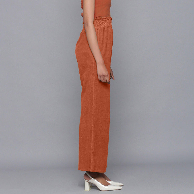 Right View of a Model wearing Sunset Rust Corduroy Striped Bootcut Pant