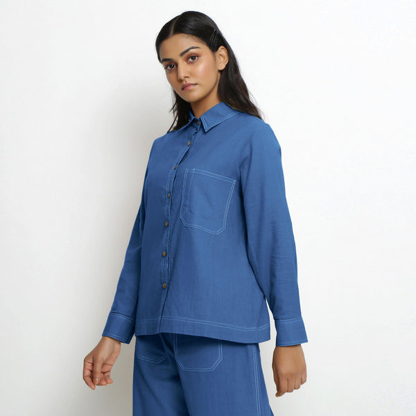 Left View of a Model wearing Vegetable Dyed Blue Button-Down Cotton Top