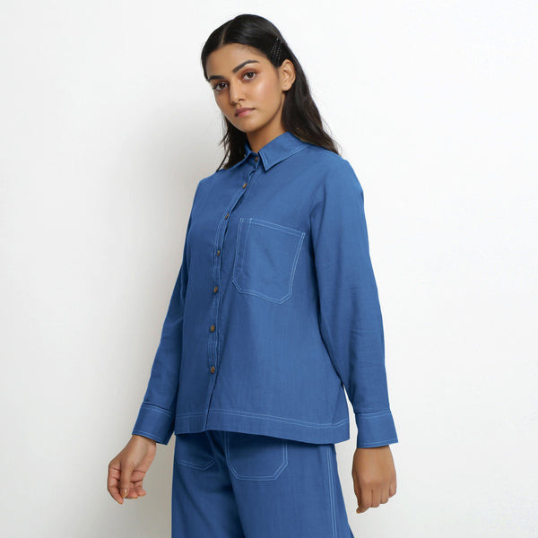 Left View of a Model wearing Vegetable Dyed Blue Button-Down Cotton Top