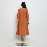 Back View of a Model wearing Vegetable-Dyed Orange 100% Cotton Button-Down Dress